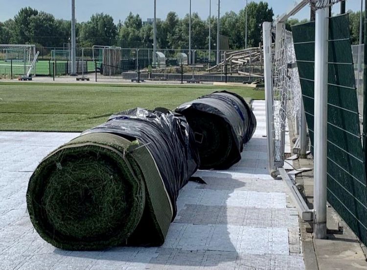 Uitrollen kunstgras op schokabsorberende onderlaag Uitrollen kunstgras op schokabsorberende onderlaag