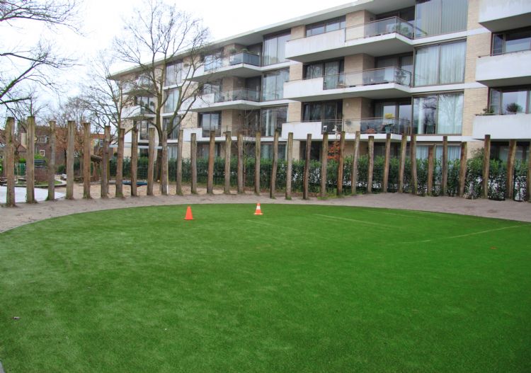 Het veld ligt naast een aantal appartementen. Het veld ligt naast een aantal appartementen.