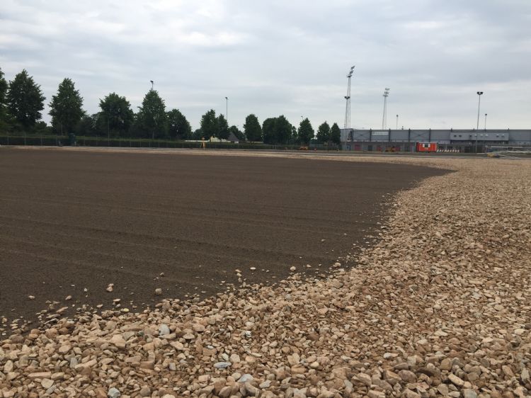 De grauwacke moet voorzichtig worden aangebracht. Onder de donkere laag ligt een waterdoorlatend doek. De grauwacke moet voorzichtig worden aangebracht. Onder de donkere laag ligt een waterdoorlatend doek.
