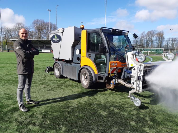Martijn Bakker (Veiligsportveld) met de reinigingsmachine op het veld bij vv Schoten