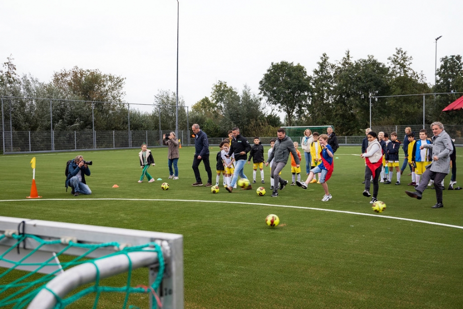 In aanwezigheid van genodigden en ruim 70 kinderen van de vereniging en hun ouders, openden wethouder sport Michiel Bunnik en kinderwethouders Rens (Duurzaamheid) en Diyae (Sport) het veld met het nemen van een duurzaamheidspenalty. (Foto: Astrid den Haan)